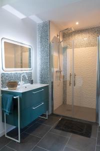 a bathroom with a blue sink and a shower at La BERGERIE DE BELESTEN in Béon