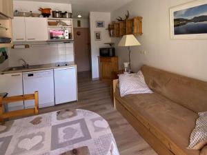 uma sala de estar com um sofá e uma cozinha em Appartement Arêches-Beaufort, 2 pièces, 4 personnes - FR-1-342-154 em Arêches