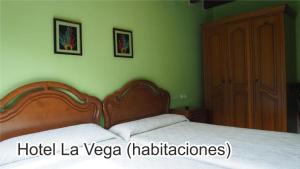 ein Schlafzimmer mit einem Bett mit einem Kopfteil aus Holz in der Unterkunft La Vega in La Vega