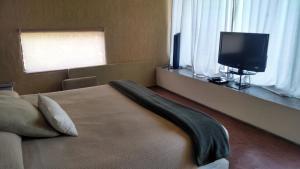 una camera da letto con un letto e una TV a schermo piatto di Hotel Boutique La Milagrosa a Tepoztlán