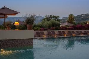 una piscina de hotel con sillas y sombrillas en Hotel Conca Park, en Sorrento
