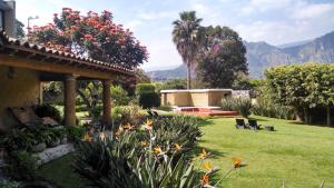 un giardino fiorito e una casa di Hotel Boutique La Milagrosa a Tepoztlán