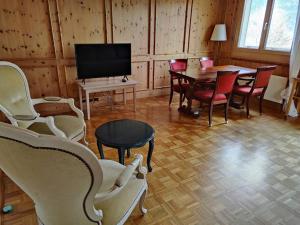 sala de estar con mesa, sillas y TV en Grosse 2 ZImmer Wohnung mit Terrasse en Bad Ragaz