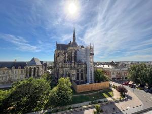 une vieille cathédrale dans une ville au soleil dans le ciel dans l'établissement Les 7 Anges - Cathédrale de Reims, à Reims