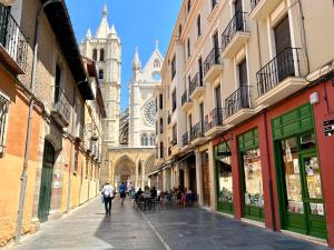 a street with people walking down a street with a cathedral at Housing León Catedral in León