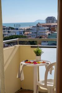 a table and chair on a balcony with a view at Hotel Oceanic in Rimini