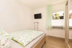 a small bedroom with a bed and a window at Ferienwohnung Schwallmann in Wilnsdorf