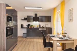 a kitchen with a table and a dining room at Ferienwohnung Schwallmann in Wilnsdorf +8 photos