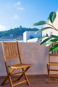 una silla de madera sentada en un balcón con una planta en Hotel Terra Linda, en Viana do Castelo