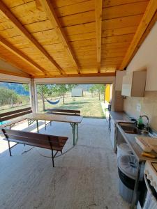 a large kitchen with tables and a large window at GLAMPING HIŠKe PETRIN in Tolmin