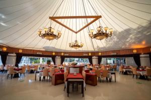 a dining hall with tables and chairs and chandeliers at Latanya Park Resort in Yaliciftlik