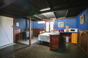 cocina con paredes azules y mesa en una habitación en The Dairy - 2 Story Rustic style accommodation with Mod Cons, en Hoddy Well