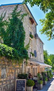a large stone building with people sitting in front of it at Luxury apartments Petrovac in Sinj