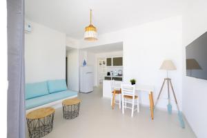 a living room with a blue couch and a table at Studio 28 in Naxos Chora