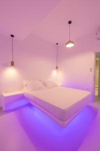 a bedroom with a bed with purple lights on it at Studio 28 in Naxos Chora +56 photos