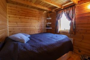 um quarto com uma cama num chalé de madeira em Golden Circle Vacation Home with hot tub & fire place em Selfoss