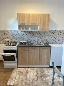 a kitchen with a white stove and a sink at Apartment SunLight in Visoko