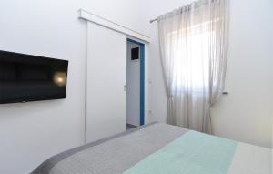 - une chambre avec un lit et une télévision à écran plat dans l'établissement House Peroj 2195, à Peroj