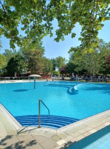 a large swimming pool with blue water at Hotel Kamilla in Balmazújváros