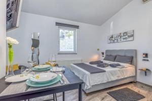 波雷奇Maximilian&Stela的一间卧室配有床和一张桌子,上面有盘子