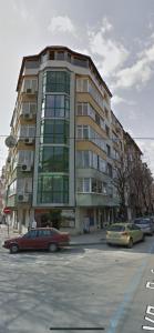 un grand bâtiment avec des voitures garées devant lui dans l'établissement White Central Apartment, à Varna