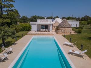 an external view of a villa with a swimming pool at HelloAPULIA - Design Trulli Sampaolo with private pool - heated on request - Pet Friendly in Gioia del Colle