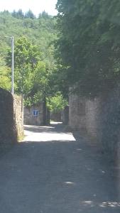 un camino vacío con una pared de piedra y árboles en Gite 4 personnes au calme et tout confort, en Saint-Vallier