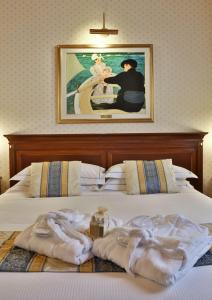 Una cama con toallas y una pintura en la pared. en Best Western Classic Hotel, en Reggio Emilia