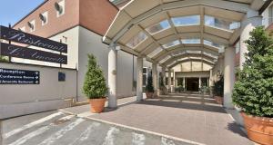 ein Gebäude mit einer Arkade mit Topfpflanzen darauf in der Unterkunft Best Western Classic Hotel in Reggio nell'Emilia