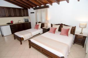 a bedroom with two beds and a kitchen at Afrodite Hotel Apartments in Myrina +37 photos