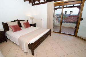 a bedroom with a large bed and a balcony at Afrodite Hotel Apartments in Myrina