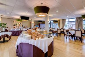 a restaurant with tables with food on them at Best Western Plus Hotel Expo in Villafranca di Verona