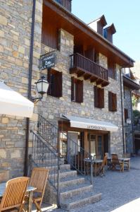 a building with chairs and tables in front of it at Habitacions La Coma de Taüll in Taull