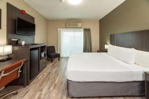 Habitación de hotel con cama grande y escritorio. en Econo Lodge City Centre Inn en Prince George