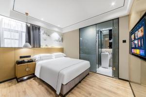 広州市にあるShangyuanHotel Quzhuang Branchのベッドとテレビがあるホテルの部屋