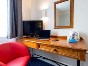 a room with a desk with a laptop and a mirror at ibis budget Glasgow Cumbernauld in Glasgow