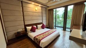 um quarto com uma cama e uma grande janela em IP Royal Hotel - Couple Friendly Near Yamuna Sports Complex, Karkardooma New Delhi em Nova Deli