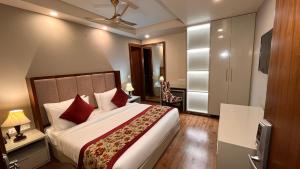 um quarto com uma cama grande e almofadas vermelhas em IP Royal Hotel - Couple Friendly Near Yamuna Sports Complex, Karkardooma New Delhi em Nova Deli