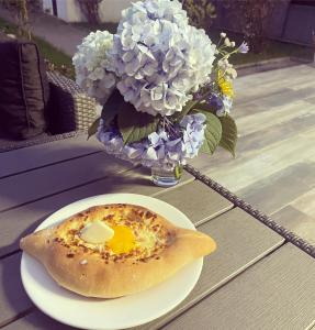 a plate with an egg in a pastry on a table with flowers at Villa Flora in Gonio