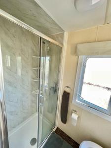 baño con ducha y puerta de cristal en 2 Bedroom Park home in Uddingston, Glasgow, en Uddingston