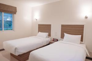 Postel nebo postele na pokoji v ubytování ONE Chumphon Hotel