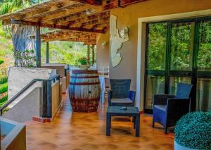 a patio with chairs and a barrel and a table at Hotel L'Oleandro in Villasimius