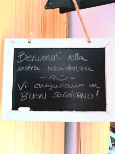 a chalkboard sign with writing on it on a string at Torretta Suite nel borgo medievale in Montone