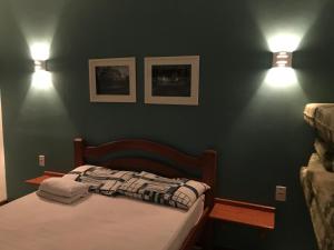 a bedroom with a bed and two lights on the wall at Sitio Maravilha in Mulungu +15 photos