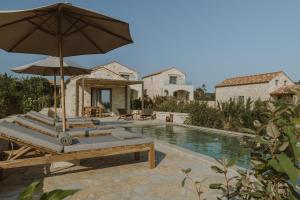 an external view of a villa with a swimming pool at Nama Seaside Villas in Paralía Kanalíou