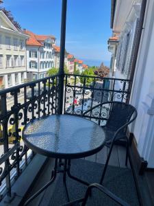 una mesa y sillas en un balcón con vistas en Appartment- Suite im Hotel Krone mit Seeblick, en Heiden