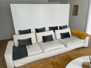 un sofá blanco con almohadas en la sala de estar en Appartment- Suite im Hotel Krone mit Seeblick, en Heiden