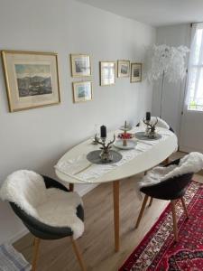 a dining room with a white table and two chairs at Appartment- Suite im Hotel Krone mit Seeblick in Heiden