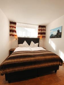 een slaapkamer met een groot bed en een raam bij Patteriol Lodge in Sankt Anton am Arlberg +23 foto's