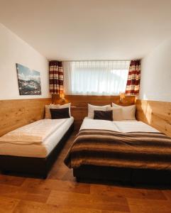 een slaapkamer met twee bedden en een raam bij Patteriol Lodge in Sankt Anton am Arlberg